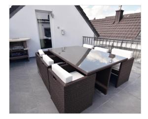 einen Esstisch und Stühle auf einer Terrasse in der Unterkunft Im Tal 2 Apartment Haus in Bergheim