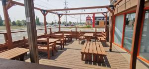 a wooden deck with wooden tables and benches on a street at Travelodge by Wyndham London Ontario in London