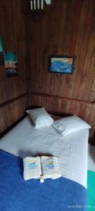 ein Schlafzimmer mit einem Bett mit zwei Handtüchern darauf in der Unterkunft Arandu Chalés in Imbituba