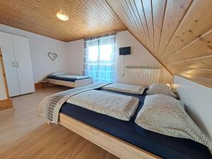 a bedroom with two beds and a wooden ceiling at Apartments Rupnik in Bovec