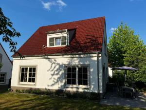 a small white house with a red roof at Villa Mina in Bad Bentheim