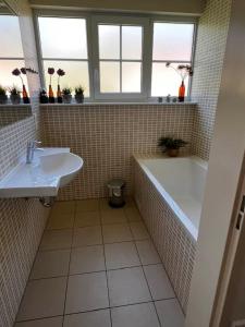 a bathroom with a bath tub and a sink at Villa Mina in Bad Bentheim