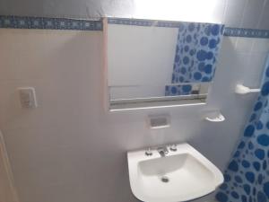 a bathroom with a white sink and a mirror at Temporario Del Centro in Paso de los Libres +13 photos