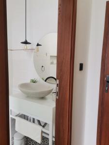 a bathroom with a white sink and a mirror at Dzixile in Gueima