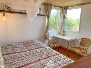 a bedroom with a bed and two chairs and a window at Luna roja in Punta Del Diablo +7 photos