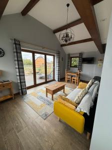 a living room with a yellow couch and a table at Rife Lodges in Arundel