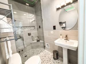 uma casa de banho com um lavatório, um WC e um espelho. em Colorado Spa Retreat / HOT TUB/SAUNA / downtown em Colorado Springs
