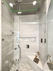 uma casa de banho branca com um chuveiro e um lavatório. em Colorado Spa Retreat / HOT TUB/SAUNA / downtown em Colorado Springs