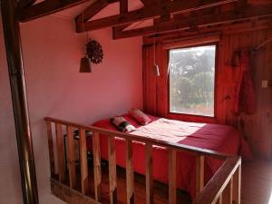 Cama pequeña en habitación con ventana en Home Loft Pichilemu, en Pichilemu