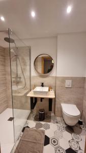 a bathroom with a sink and a toilet and a mirror at Chalet Terejo & spa in Ventron