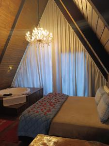 1 dormitorio con cama y lámpara de araña en Chalés Capivari Diamante en Campos do Jordão
