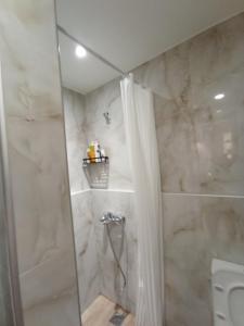bagno con doccia e tenda doccia di Ethereum City Αpartment - Suite a Chania