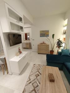 a living room with a blue couch and a table at Ethereum City Αpartment - Suite in Chania Town