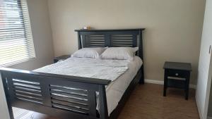 a bedroom with a black bed with white pillows at 2 bedroom morden apartment in Fairview