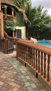 a house with a wooden railing next to a swimming pool at Hidden oasis in Mandeville