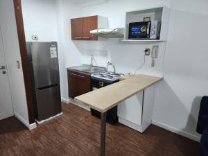 a small kitchen with a stove and a refrigerator at Vivaceta Metro Hospitales in Santiago