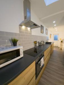 カーディフにあるPlenty of Parking Available; 3 Bedroom Apartment by Property Promiseのキッチン(黒いカウンタートップ、電子レンジ付) +32枚の写真