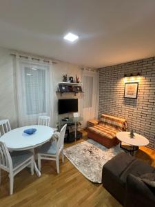 een woonkamer met een tafel en een bank bij Apartman Trklja in Kotor
