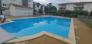 a large blue swimming pool in a yard at Rêve de Bisca Appartement spacieux avec jardin privatif piscine et parking privés in Biscarrosse