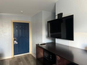 a room with a flat screen tv and a blue door at Budget Inn Danville in Danville