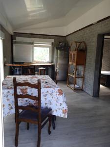 a bedroom with a bed and a chair and a kitchen at Casa en la Bota, Manantiales in Manantiales