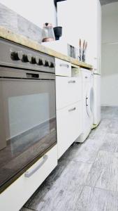 uma cozinha com um fogão e uma máquina de lavar e secar roupa em Family Studio in AKH Area em Viena