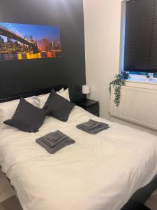 a white bed with two towels on top of it at Sleek Cosy Flat Camden in London