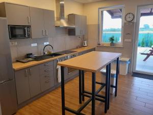 a kitchen with a wooden table and a large window at Akacja in Skotniki