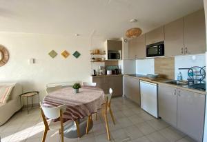 eine Küche und ein Esszimmer mit einem Tisch und Stühlen in der Unterkunft Escale paisible à Sète, belle terrasse vue sur mer in Sète