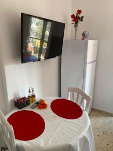 eine Küche mit einem roten und weißen Tisch und einem TV in der Unterkunft RETIRO V - Los Quesitos in Denia