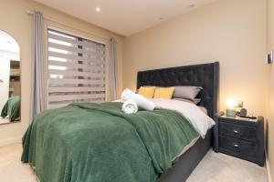 sypialnia z łóżkiem z zielonym kocem i oknem w obiekcie Entire Apartment - City Centre - Free Parking w mieście York