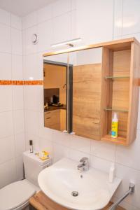 een badkamer met een wastafel en een spiegel bij MountainLOVE in Strobl