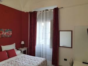 um quarto com uma cama e uma janela com cortinas vermelhas em B&B Da Rosa em Linguaglossa