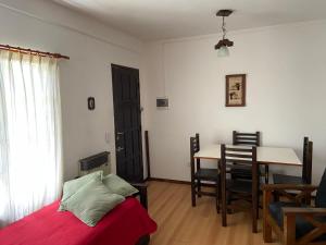 1 dormitorio con cama, mesa y comedor en ARENAS 4 en Villa Gesell