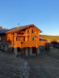 a large wooden house with a large deck at Chalet en rondins avec magnifique vue in Font-Romeu-Odeillo-Via