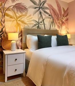 a bedroom with a bed with a tropical wallpaper at Blush Jungle in Dublin