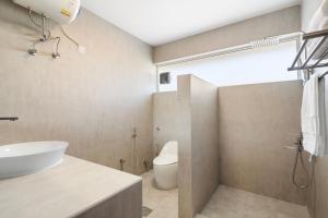 Jumeirah Three Bedroom House في دبي: حمام مع حوض أبيض ومرحاض