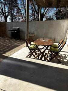 a table and two chairs and a grill on a patio at Superbe appartement dans un mas in Nîmes