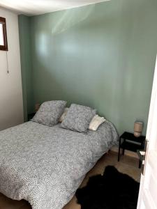 een slaapkamer met een bed met twee kussens erop bij Superbe appartement dans un mas in Nîmes