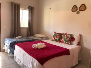 a bedroom with two beds and a red blanket at Pousada Chácara do Coqueiro in Barreirinhas