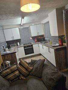 a living room with a couch in a kitchen at Pinewood house 