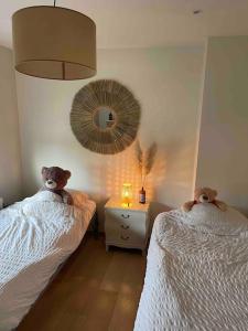 um quarto com duas camas com ursos de peluche sentados sobre eles em Happiness at Lili em Verviers