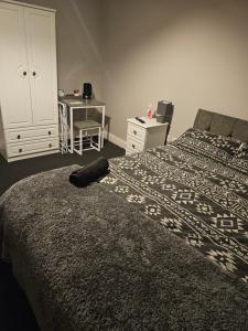 a bedroom with a bed with a dresser and a desk at Pinewood house 