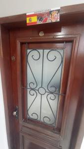 uma porta de madeira com uma janela de vidro em Vaccani Apart em Macaé