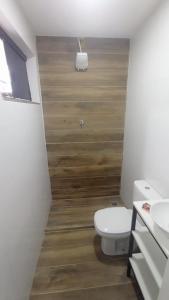 a bathroom with a toilet and a sink at Vaccani Apart in Macaé