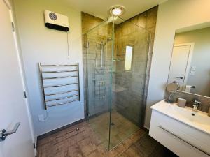 a bathroom with a glass shower and a sink at Maple Retreat by Blue Spring in Putaruru