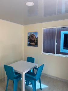 ein Esszimmer mit einem Tisch und blauen Stühlen in der Unterkunft Casa Nativa DUDA´S in Franshua