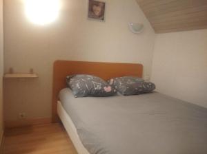 a bedroom with a bed with two pillows on it at Charmant Appartement in Saint Malo