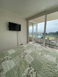 een slaapkamer met een bed, een televisie en een balkon bij Bella vista, disfrútala! in Petorca