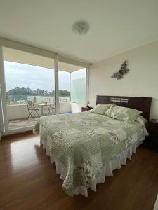 een slaapkamer met een bed en een groot raam bij Bella vista, disfrútala! in Petorca